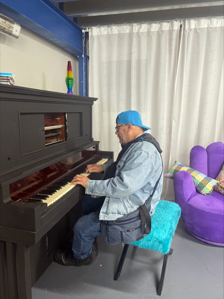 An NDIS participant plays piano in one of our day programs